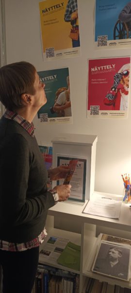 Museon asiakas katselee Näyttely Sastamalasta -hankkeen värikkäitä julisteita.